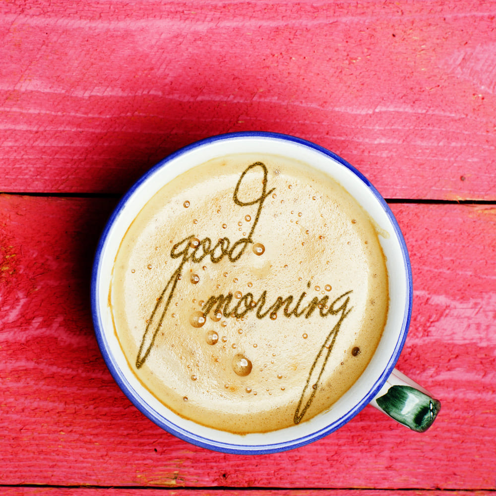 A great cup of morning coffee on a red board.